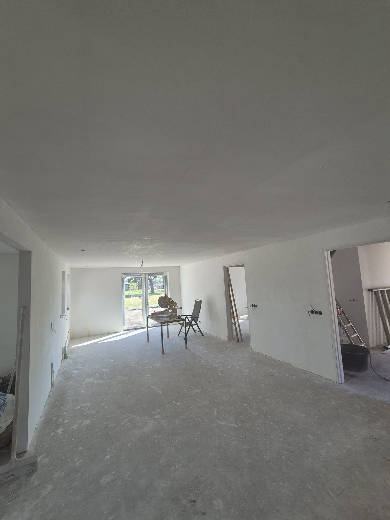 Een hele benedenverdieping met net gestucte, gladde wanden en plafond